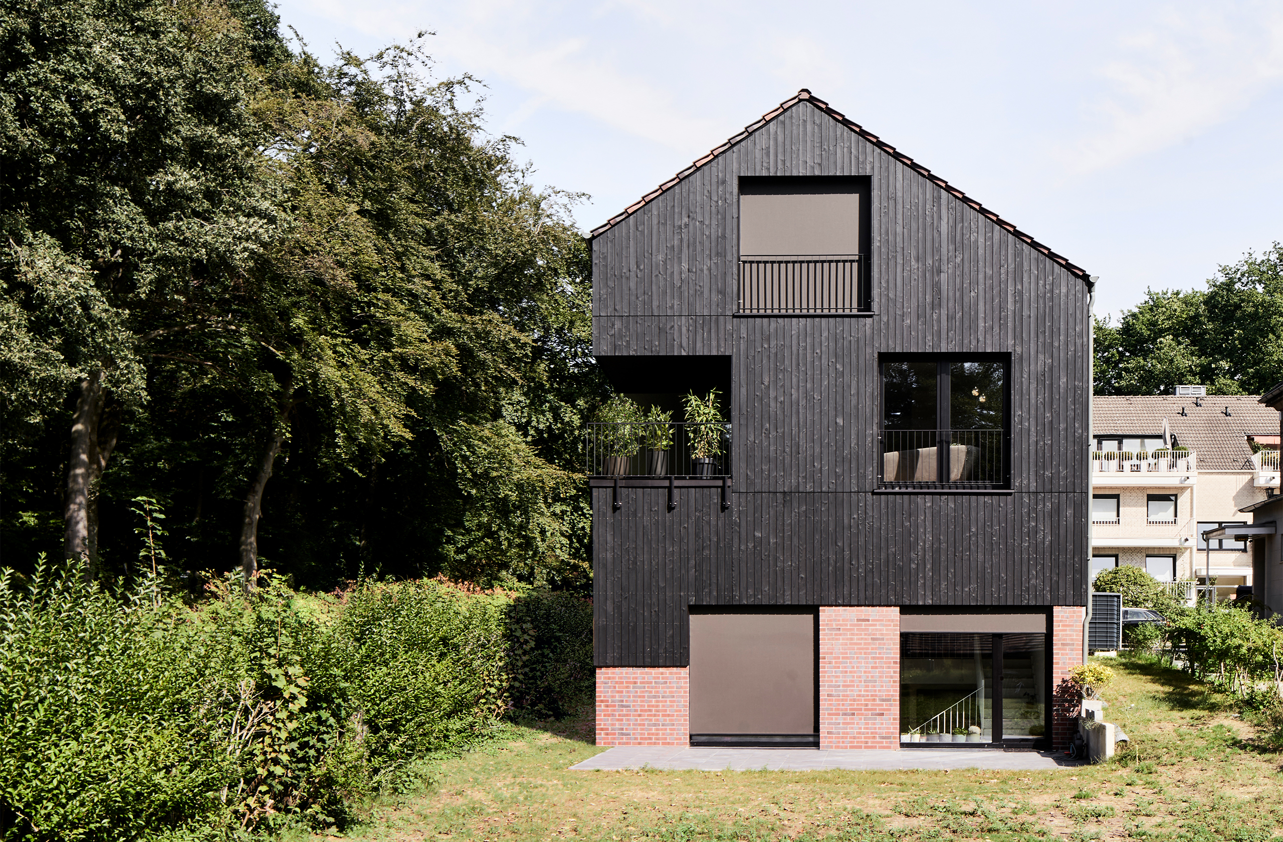 Rückansicht des Mehrfamilienhauses mit Gartenbereich