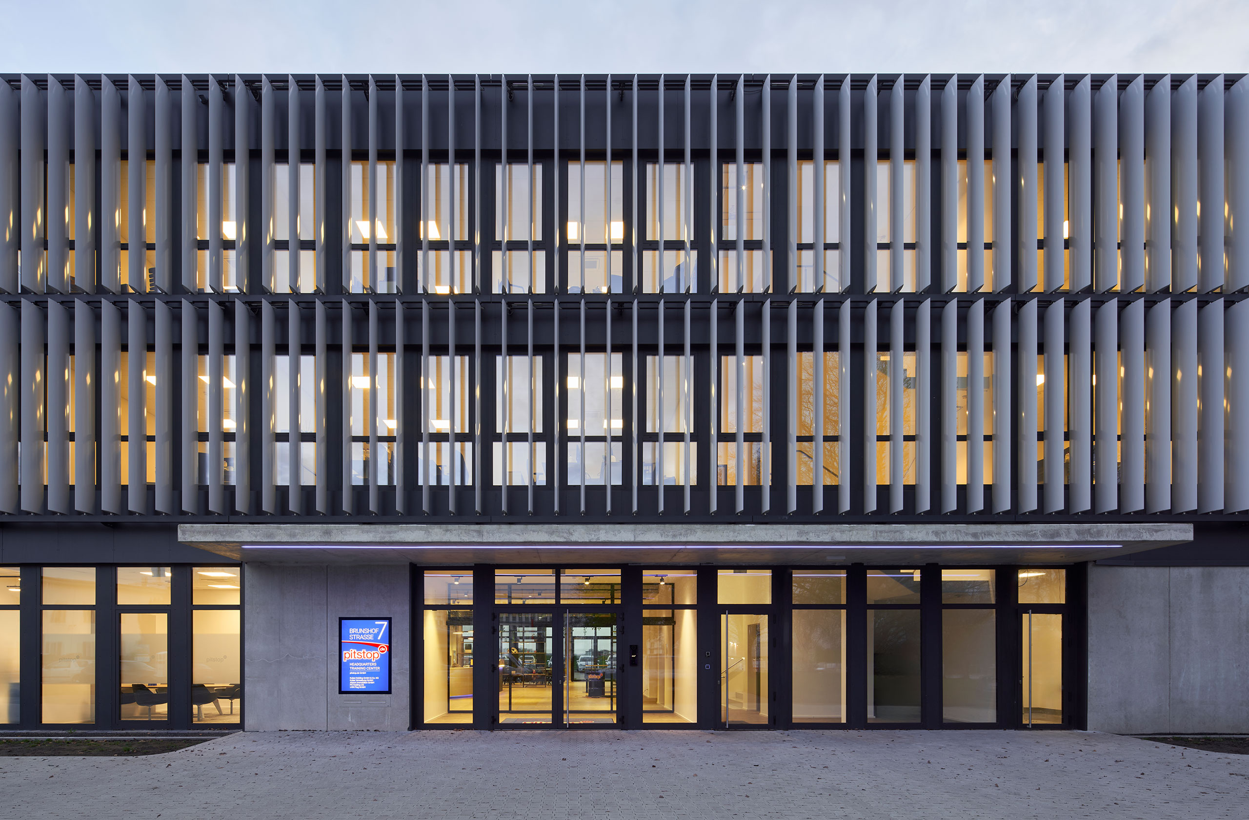 Vorderansicht der Hauptverwaltung pitstop mit Haupteingang und Firmenlogo