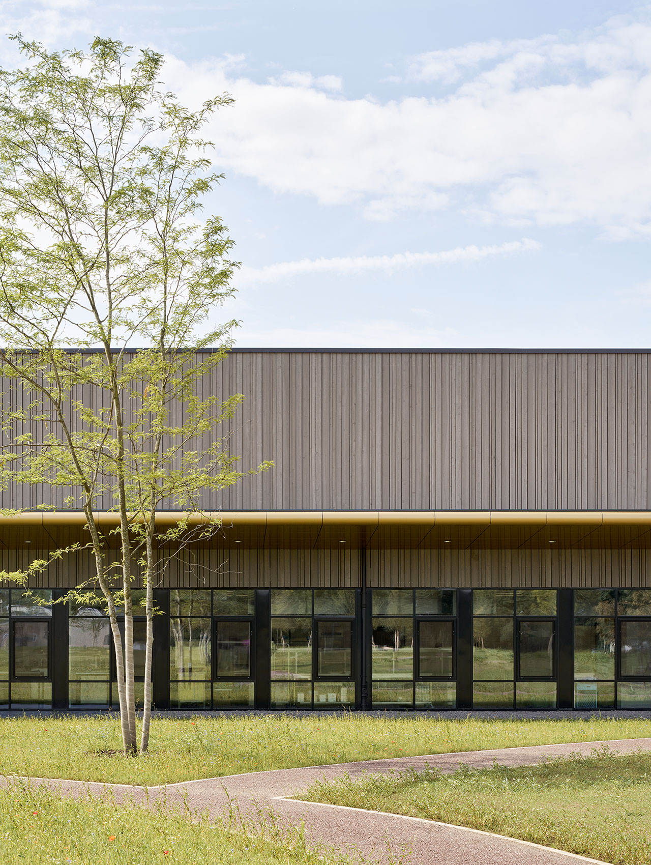 Außenansicht der umgebauten Logistikhalle mit Begrünung