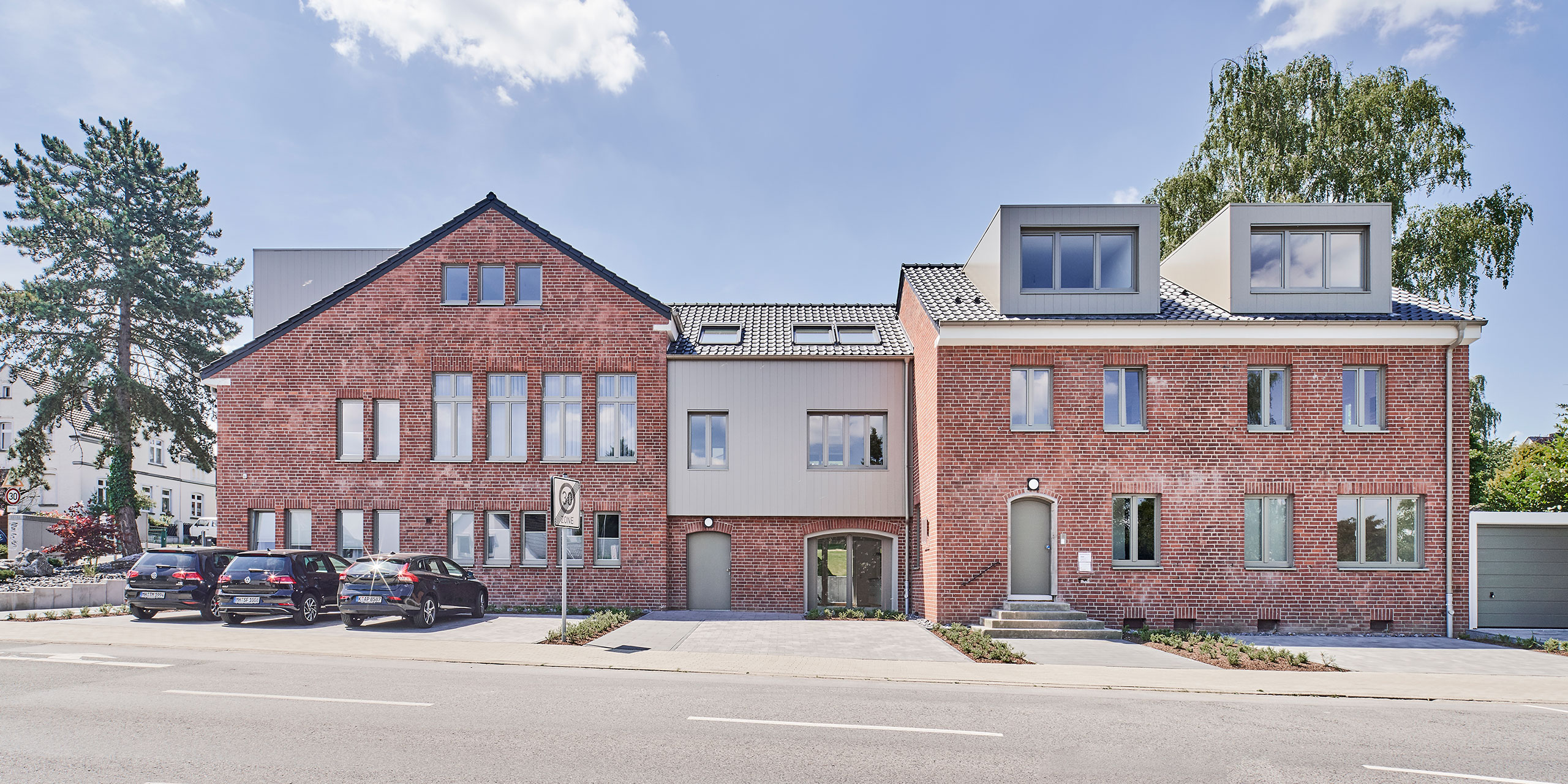 Straßenansicht der umgebauten Kirche mit erhaltener Ziegelfassade
