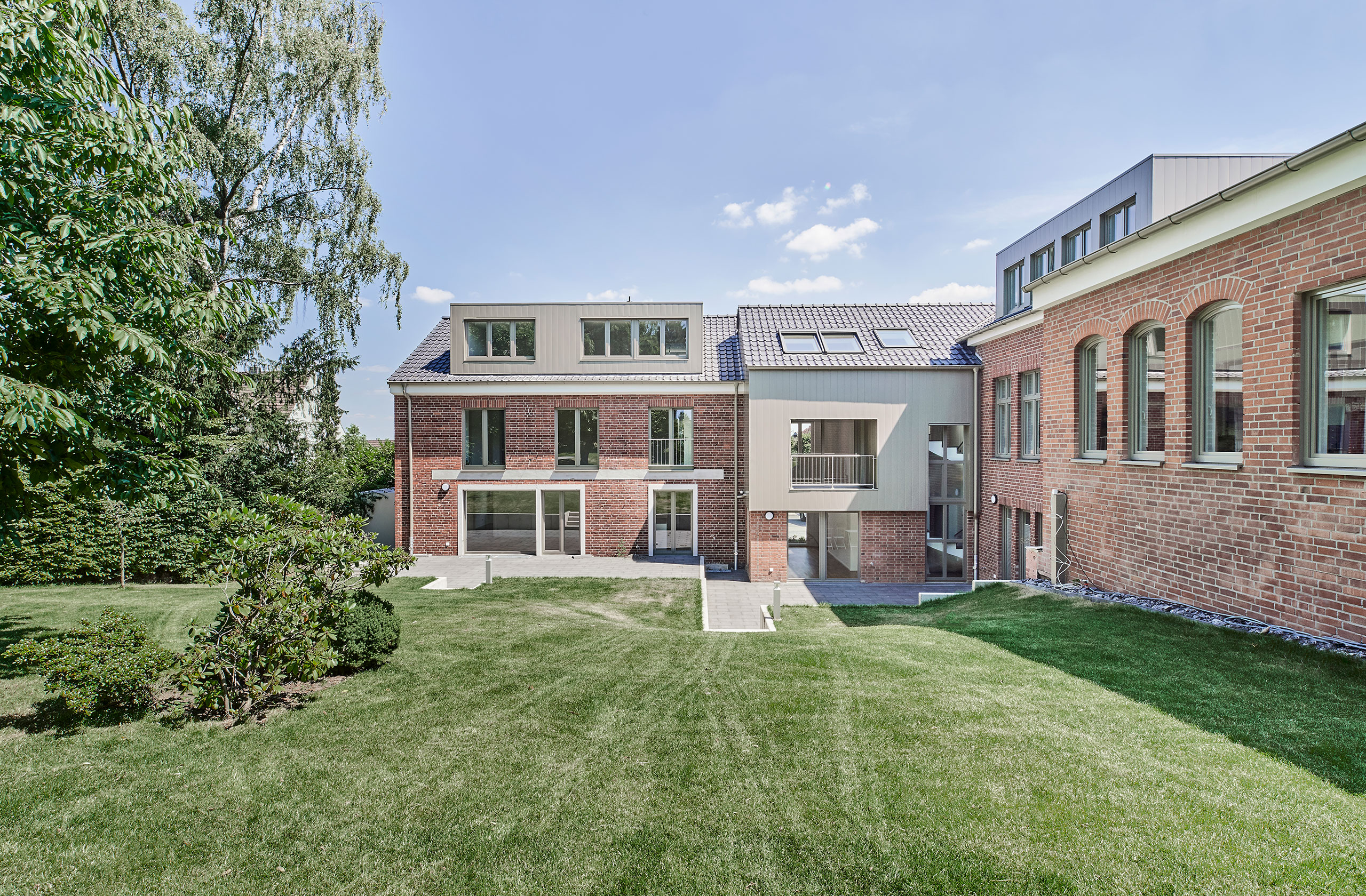 Rückansicht der ehemaligen Kirche mit begrüntem Gartenbereich
