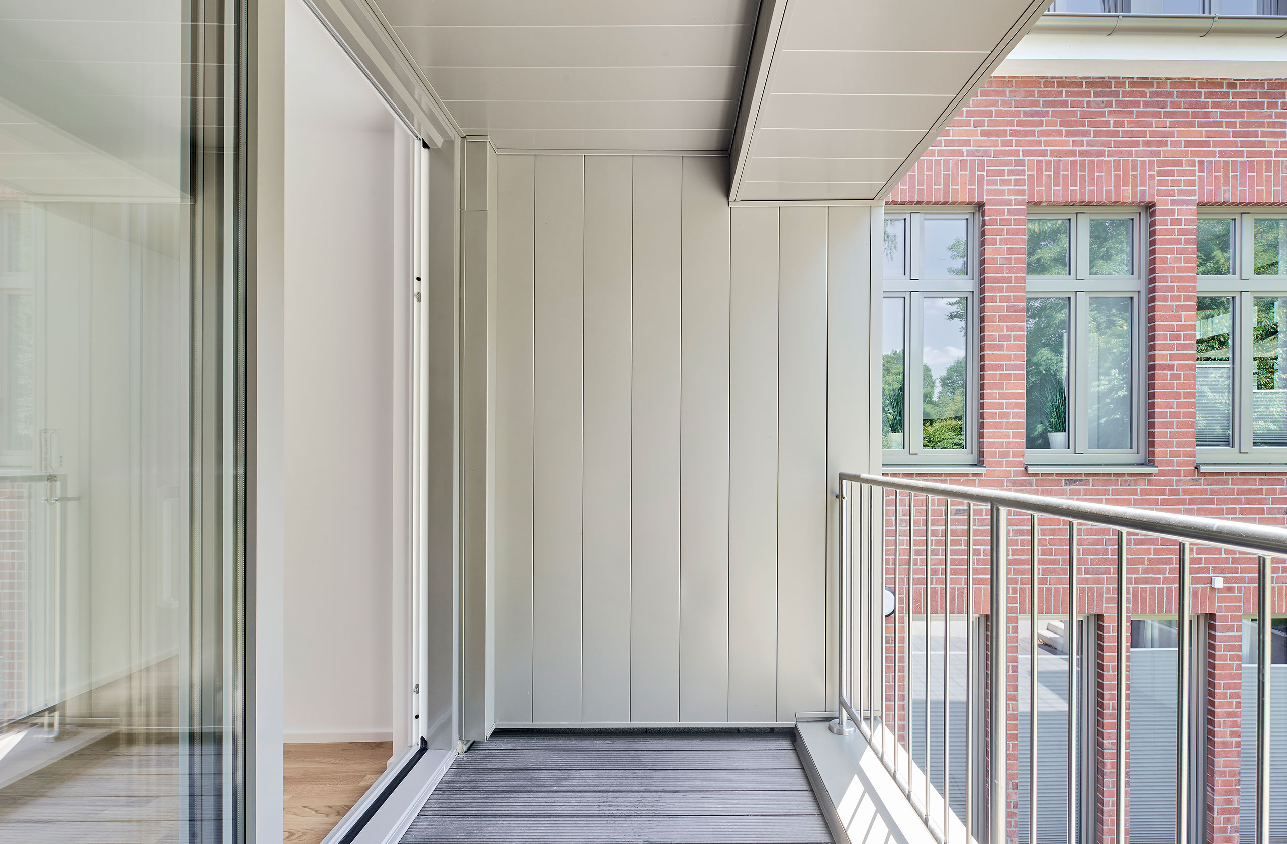 Loggia mit moderner Metallverkleidung und Blick auf den Backsteinbau