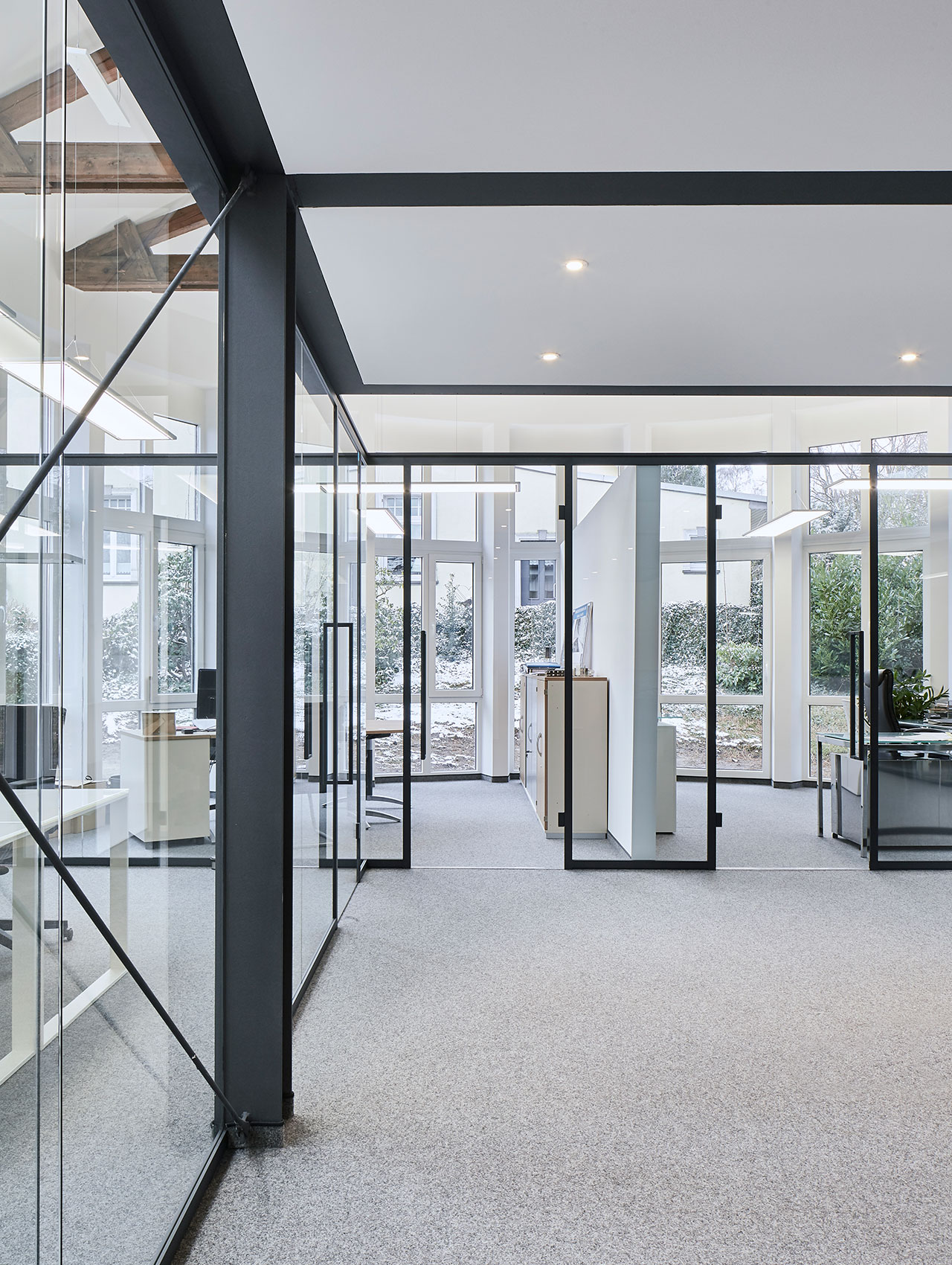 Offene Arbeitsfläche mit Glasfassade und modernen Raumelementen