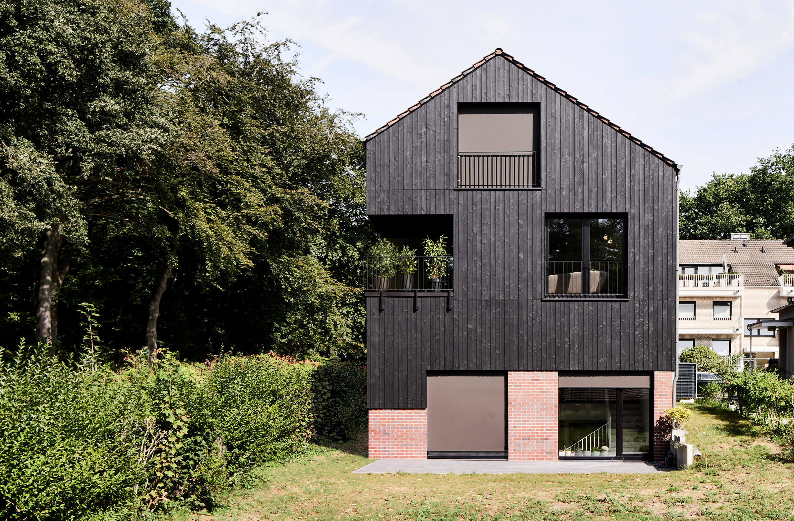 Rückansicht des Mehrfamilienhauses mit Gartenbereich