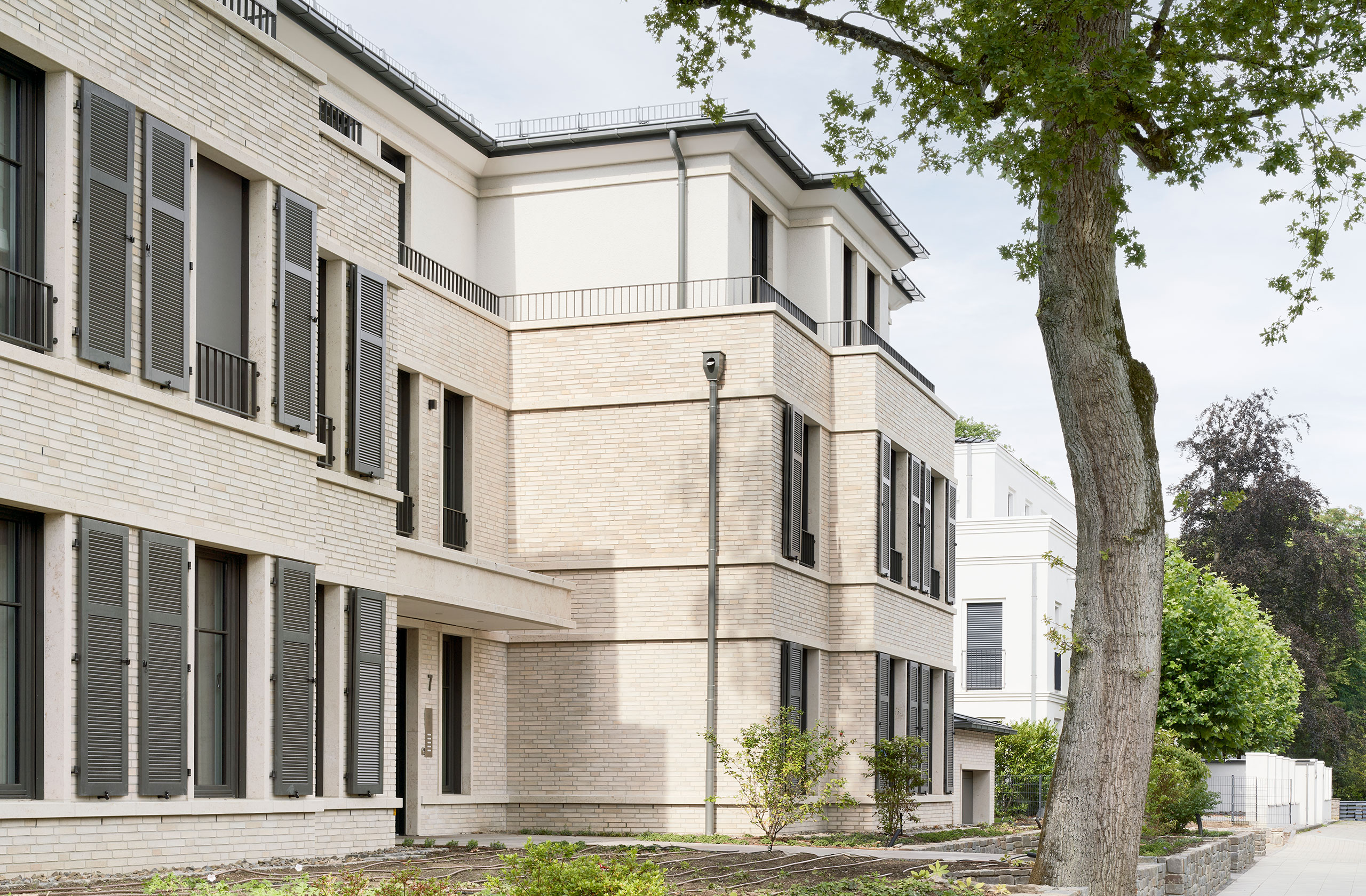 Seitenansicht des Gebäudes mit vertikal gegliederter Fassade und Fensterläden