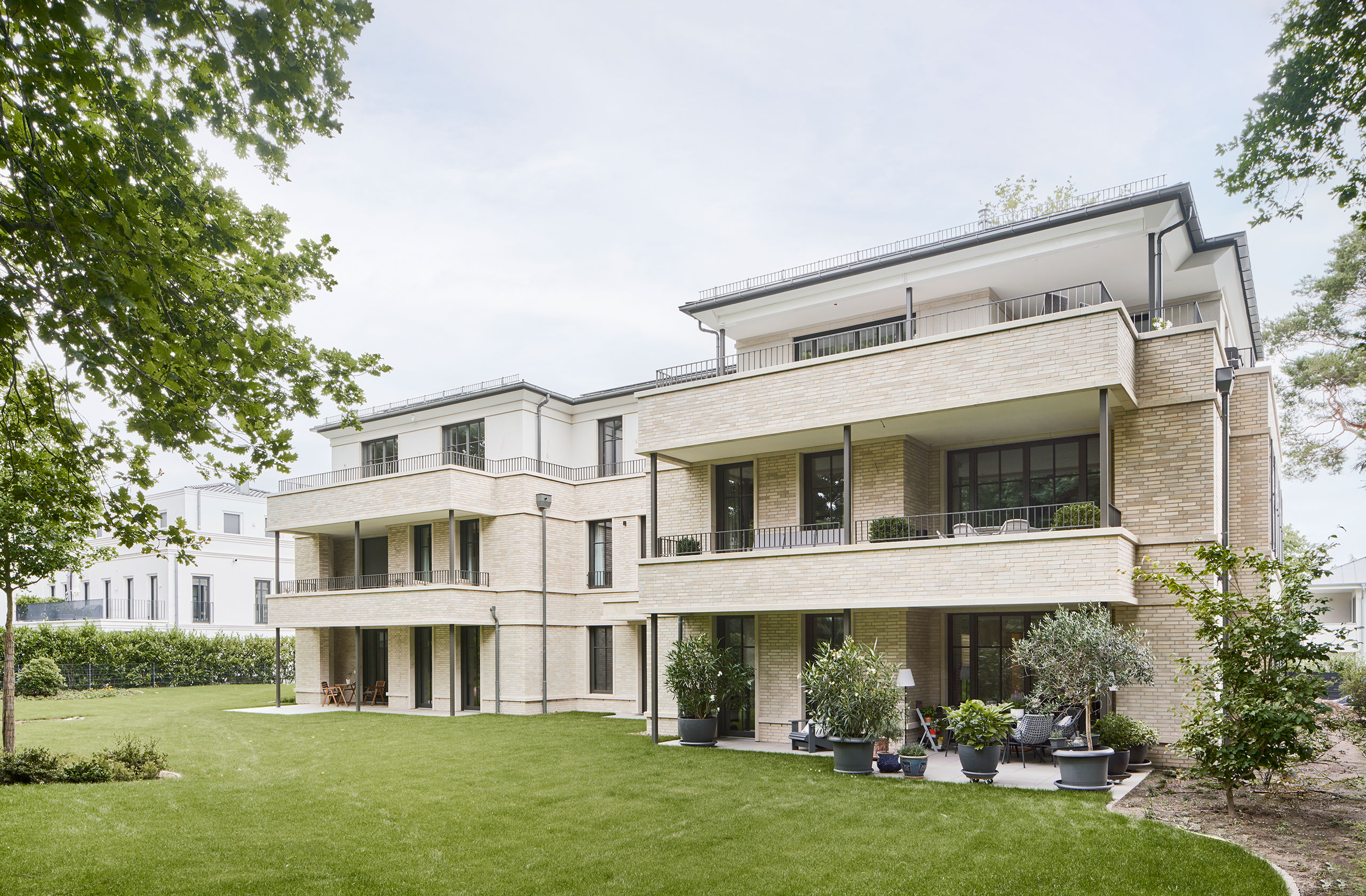 Gartenansicht des Mehrfamilienhauses mit großzügigen Terrassen und Balkonen
