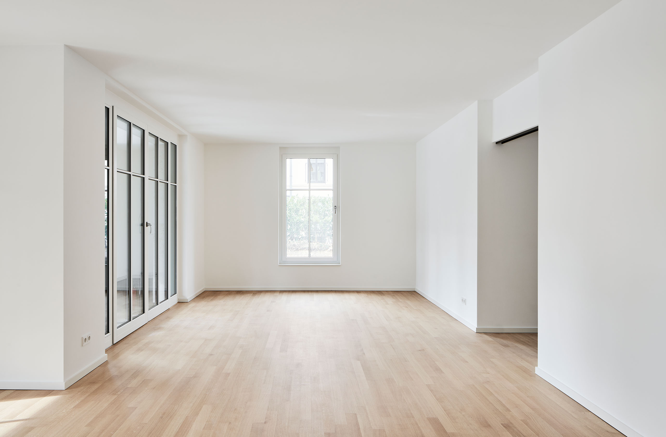 Wohnraum mit Eichenparkett und bodentiefen Fenstern