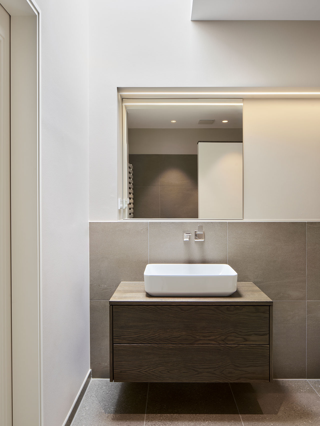 Badezimmer mit Wandwaschtisch und ruhiger Farbgestaltung in Naturtönen