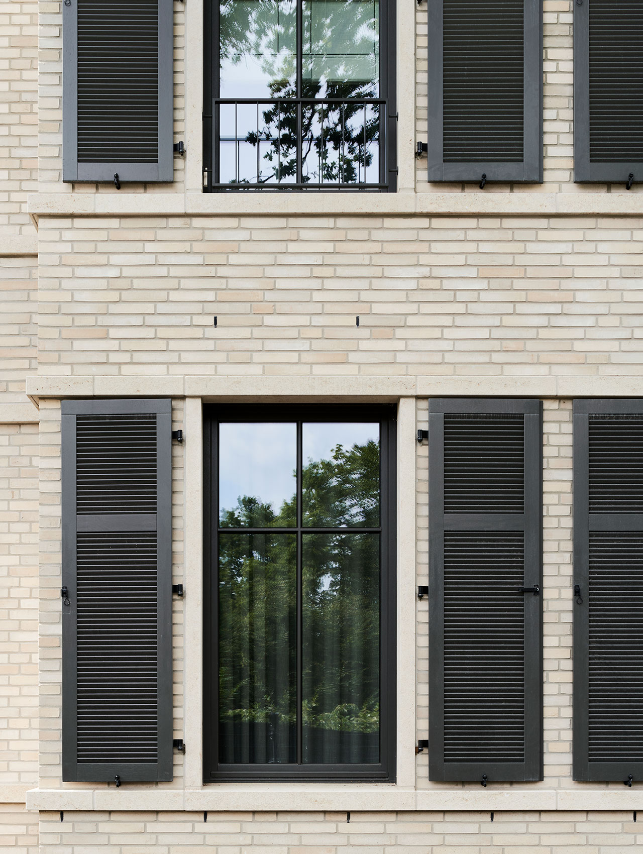 Fassadendetail mit dunklen Fensterläden und strukturierter Klinkeroberfläche