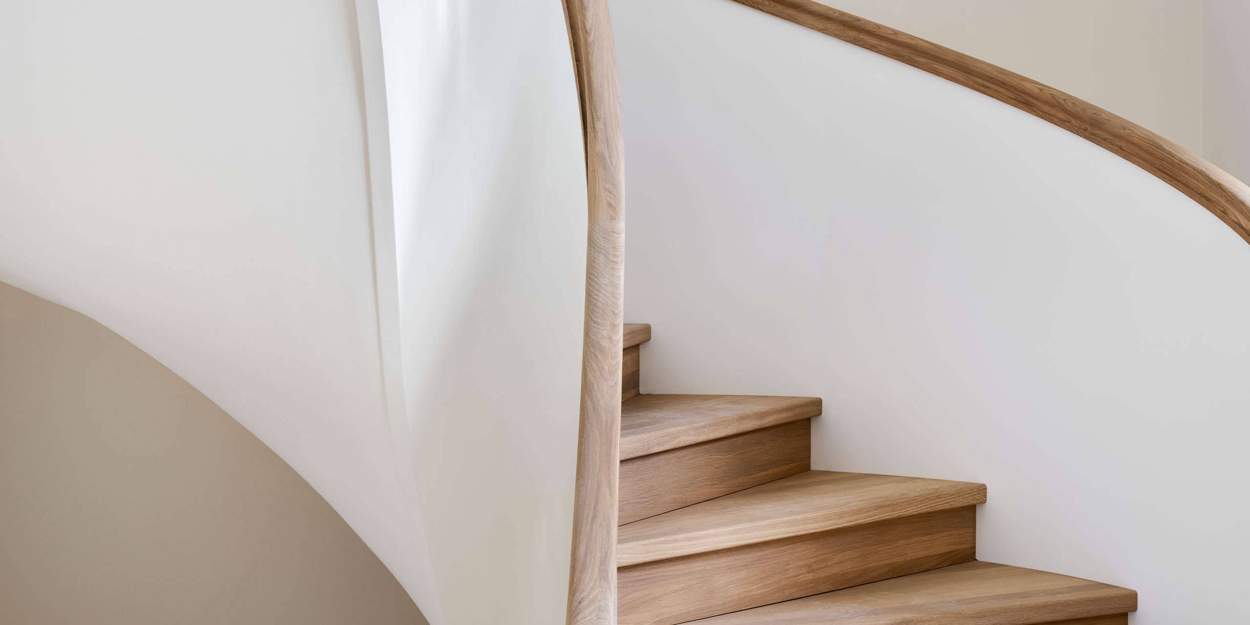 Geschwungene Treppe mit Holzhandlauf