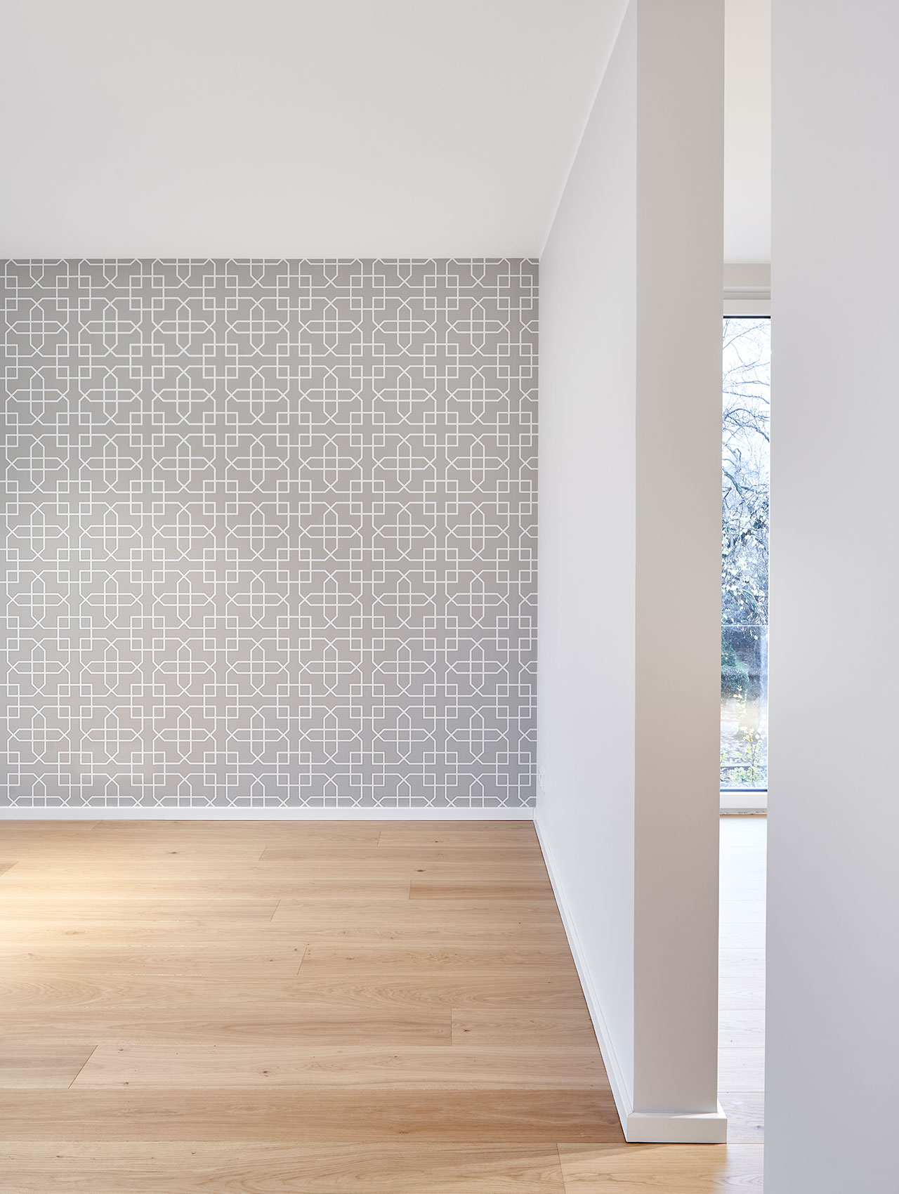 Wohnraum mit grafischer Tapete und hellem Parkettboden