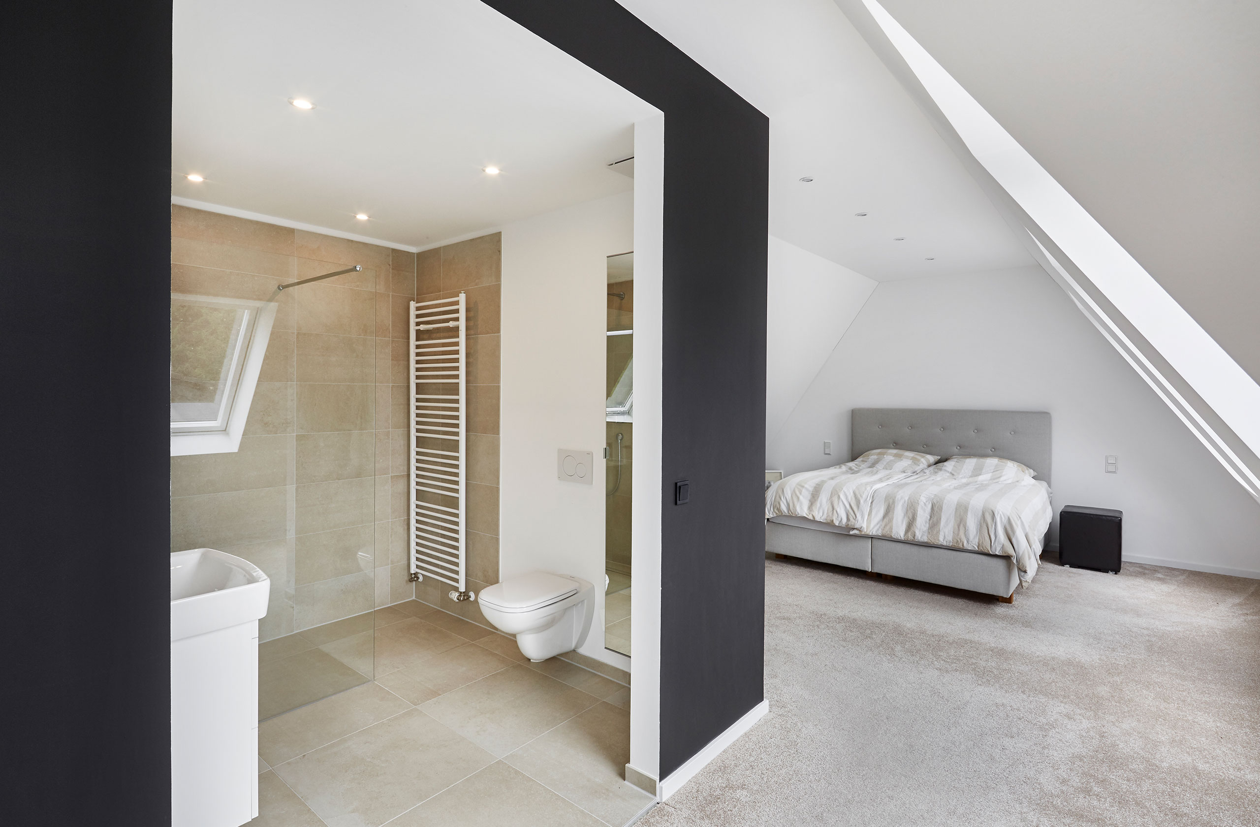 Schlafzimmer im Dachgeschoss mit offenem Badbereich und schrägen Decken