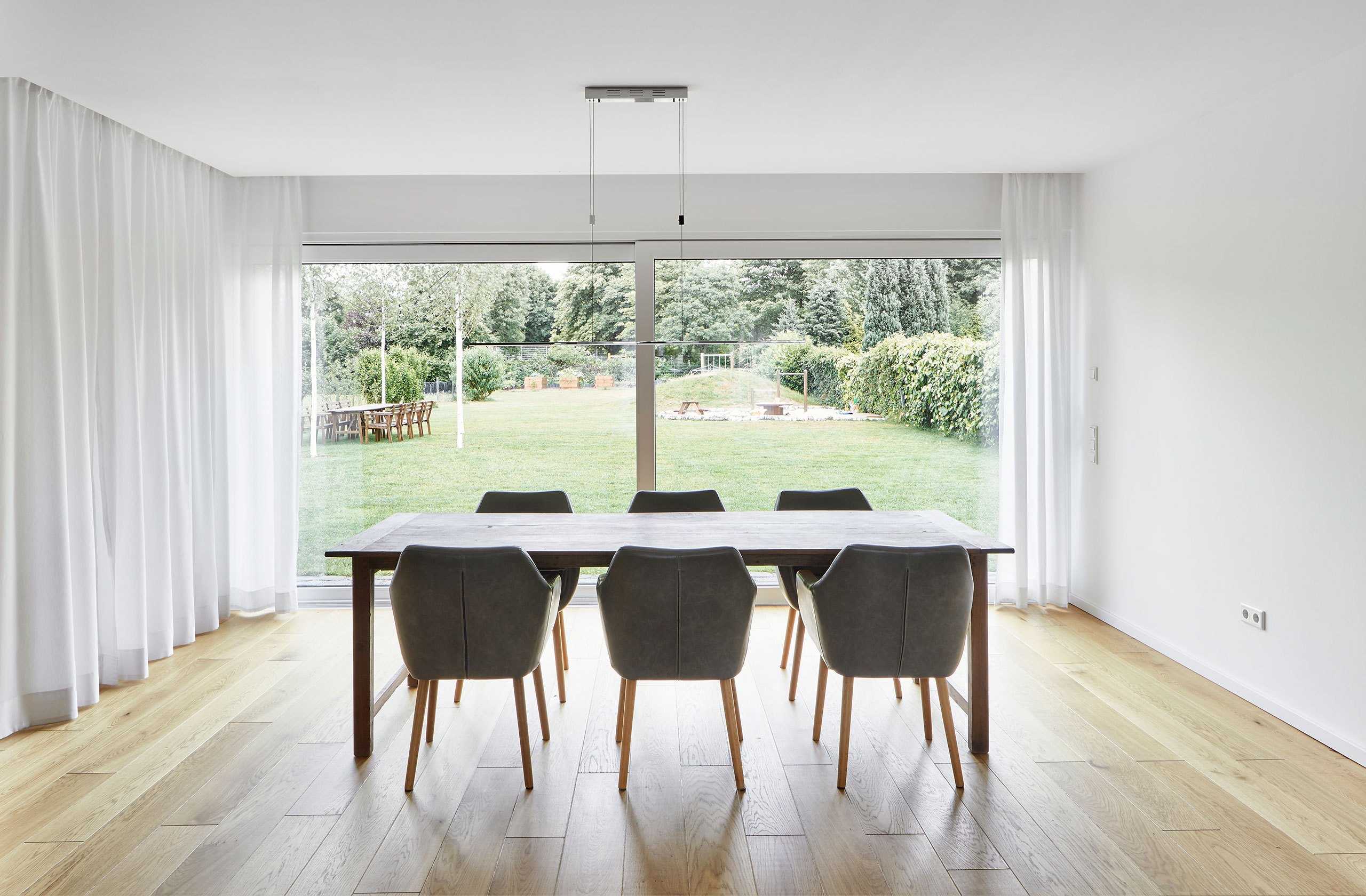 Helles Esszimmer mit großem Fenster zum Garten