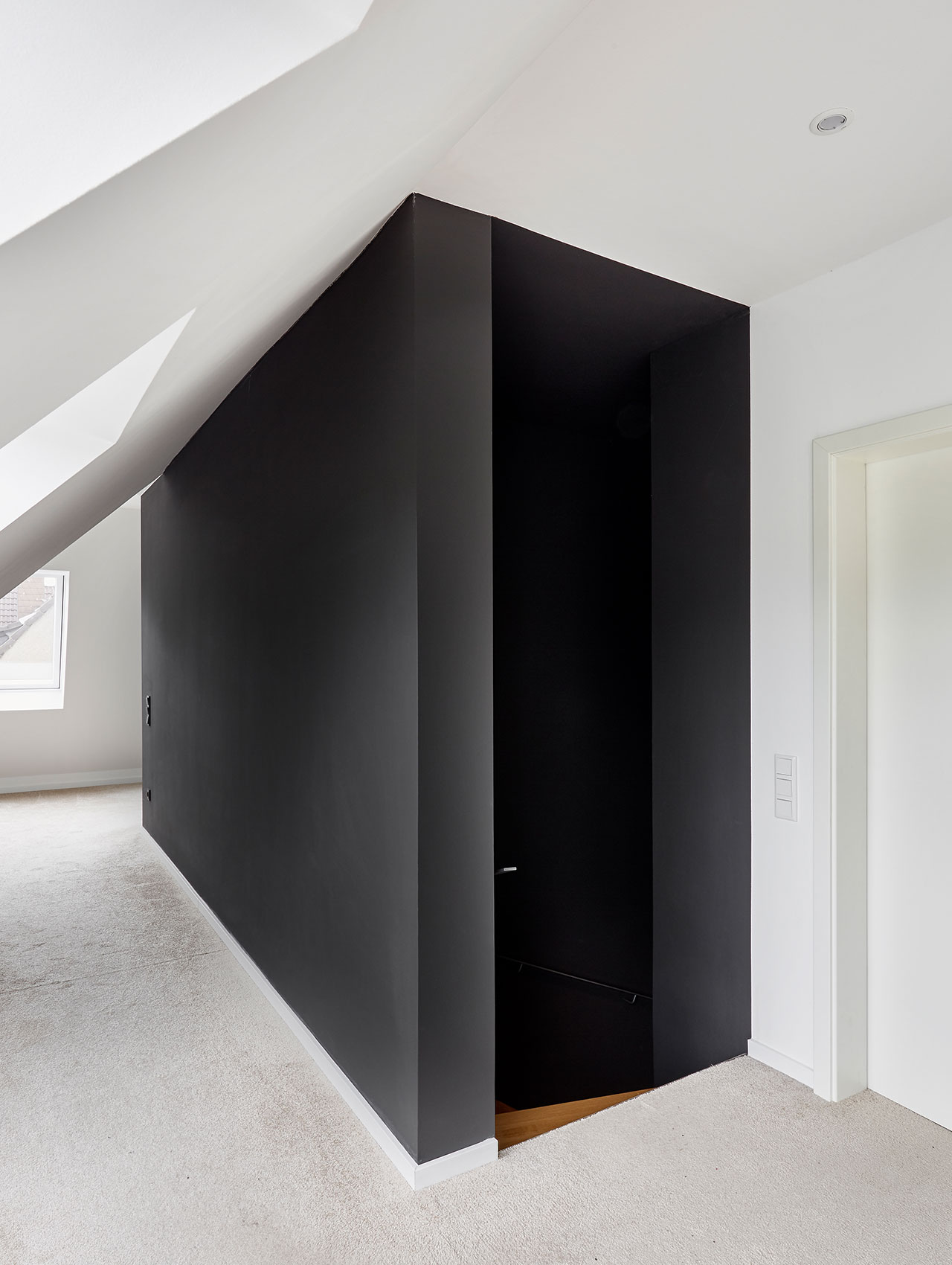 Flur im Obergeschoss mit schwarzer Wand und Teppichboden