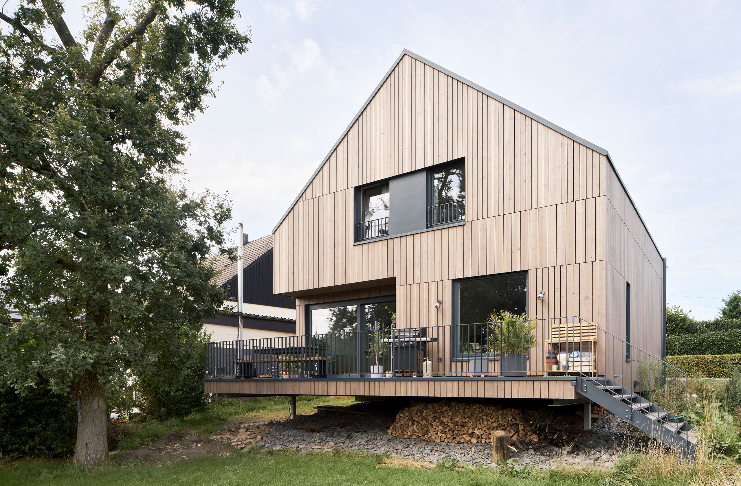 Rückansicht des Wohnhauses VB9 mit Terrasse und Holzfassade