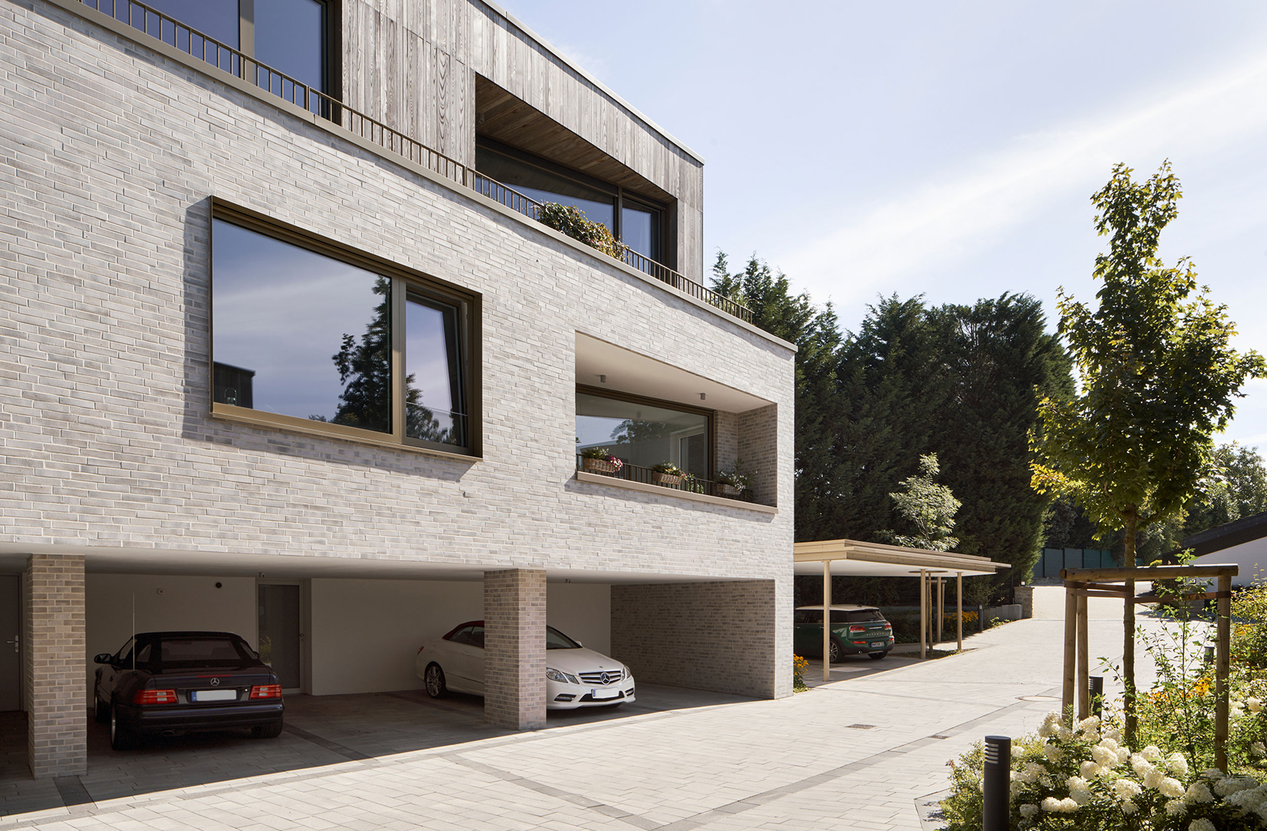 Carport- und Eingangszone mit vorgelagerter Pflanzung und hellem Klinker