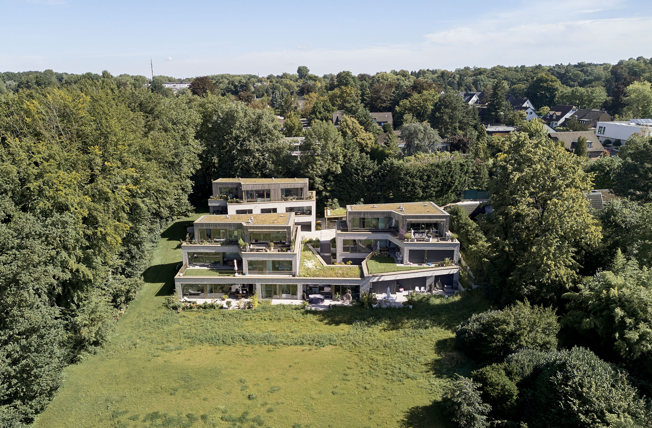 Luftaufnahme des terrassierten Wohnquartiers am Waldrand