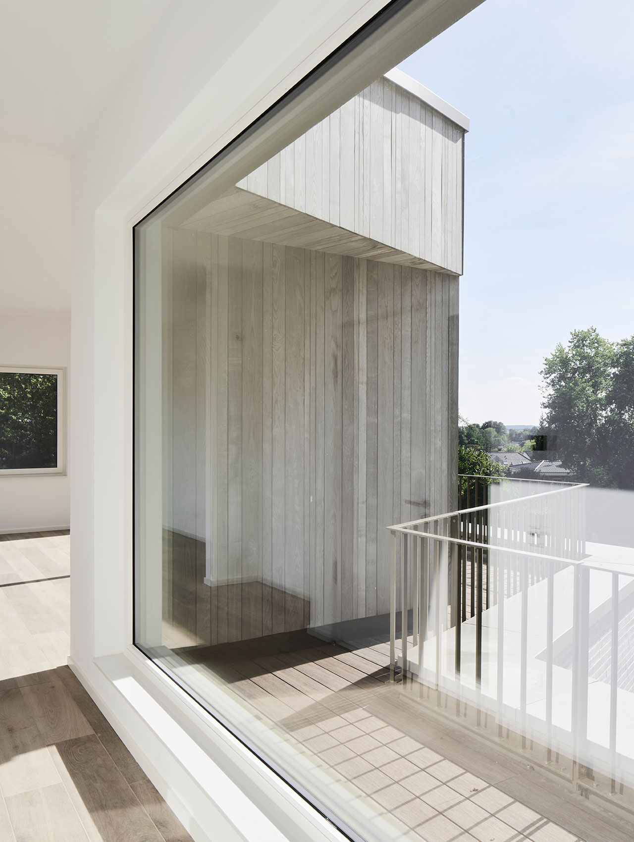 Balkon mit Sichtbetonverkleidung und bodentiefen Fenstern