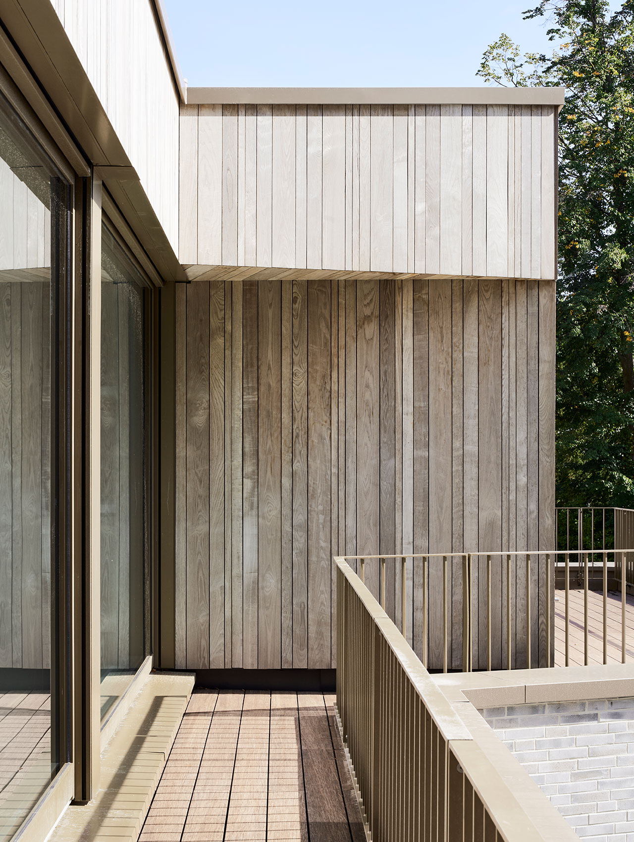 Detailansicht eines Balkons mit vertikaler Holzverschalung